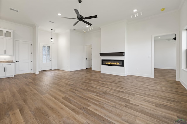 111 Mia Ln, Longview, TX 75604 - unfurnished living room featuring a ceiling fan, ornamental molding, light wood finished floors, a glass covered fireplace, and baseboards