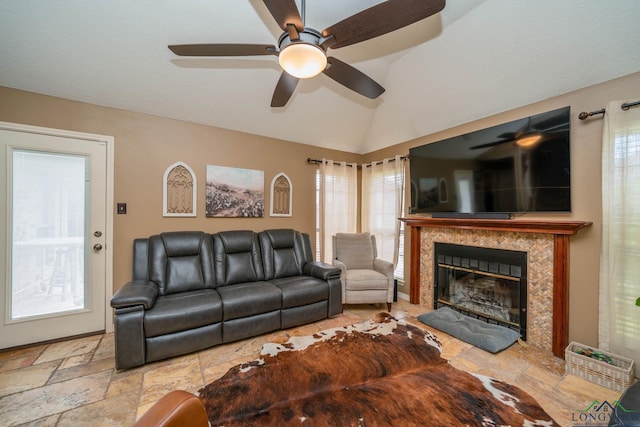 202 Mill Run Dr, Longview, TX 75604 - living area with ceiling fan, vaulted ceiling, a fireplace, stone tile flooring, and plenty of natural light