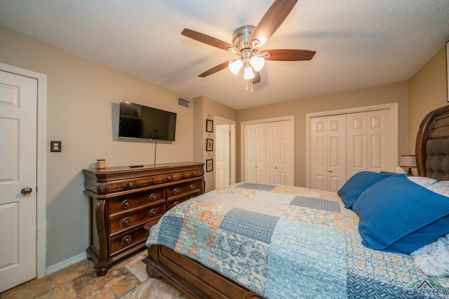 202 Mill Run Dr, Longview, TX 75604 - bedroom with two closets, a ceiling fan, and stone finish floors