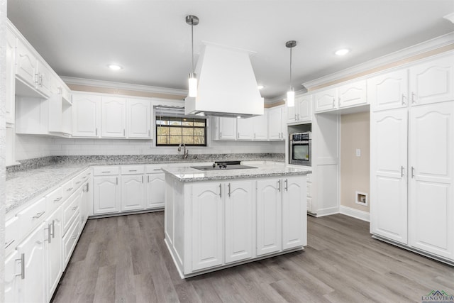 kitchen with decorative light fixtures, oven, white cabinetry, and light stone counters