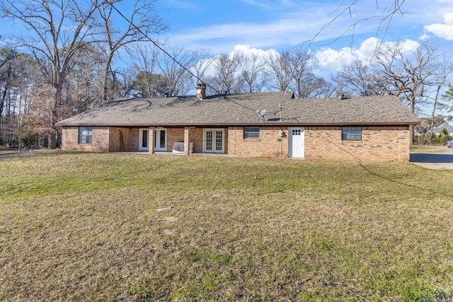 back of house featuring french doors and a lawn