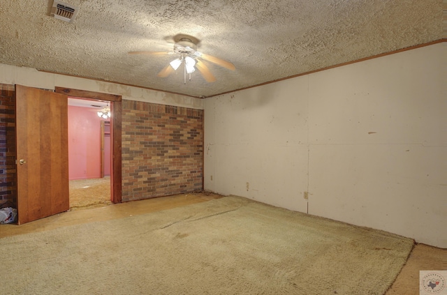 empty room with crown molding, brick wall, a textured ceiling, and carpet