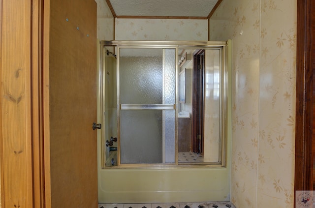 bathroom with shower / bath combination with glass door and a textured ceiling