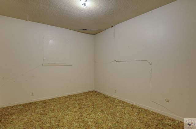 empty room with carpet floors and a textured ceiling