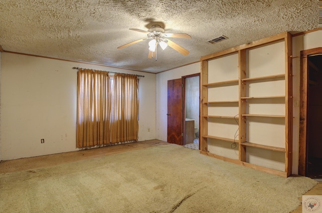 basement with ceiling fan, ornamental molding, carpet flooring, and a textured ceiling