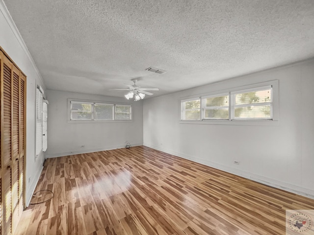 unfurnished bedroom featuring ceiling fan, a textured ceiling, and light hardwood / wood-style flooring