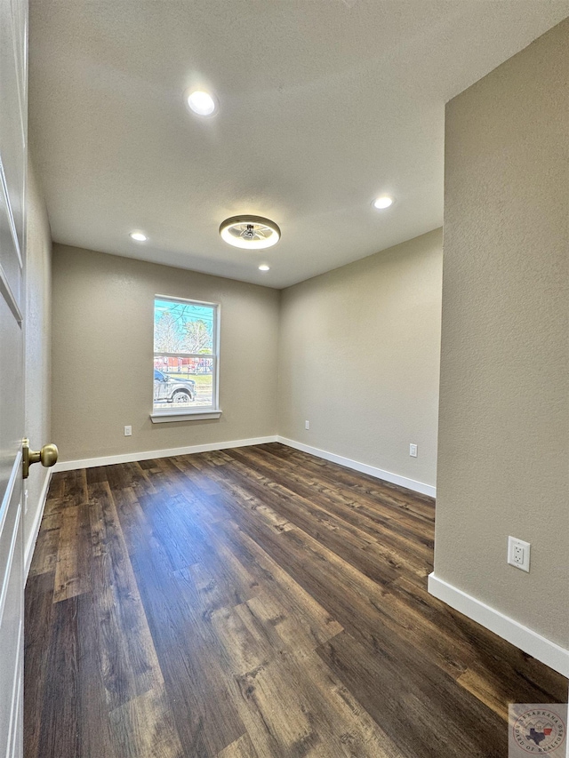 unfurnished room featuring recessed lighting, dark wood finished floors, and baseboards