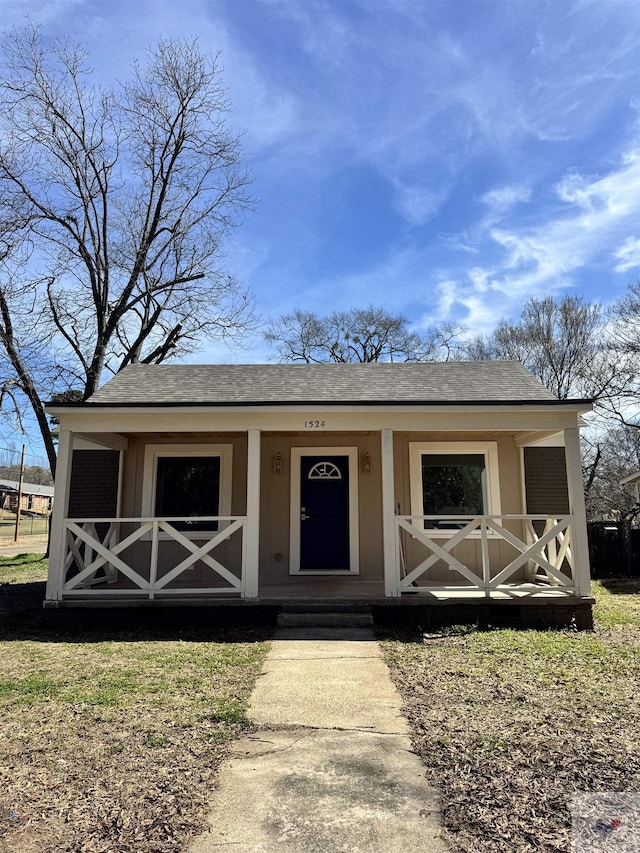 view of front facade featuring covered porch and a shingled roof