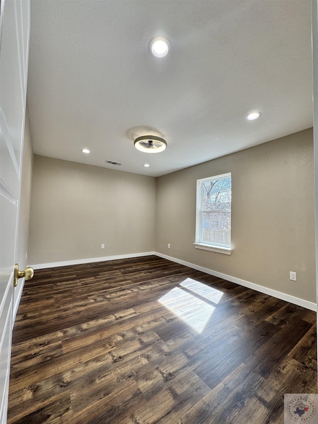 spare room featuring baseboards, visible vents, dark wood finished floors, and recessed lighting