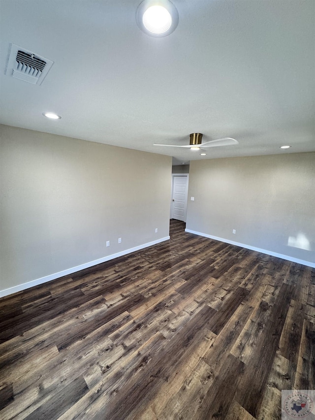 spare room featuring visible vents, dark wood finished floors, baseboards, and ceiling fan