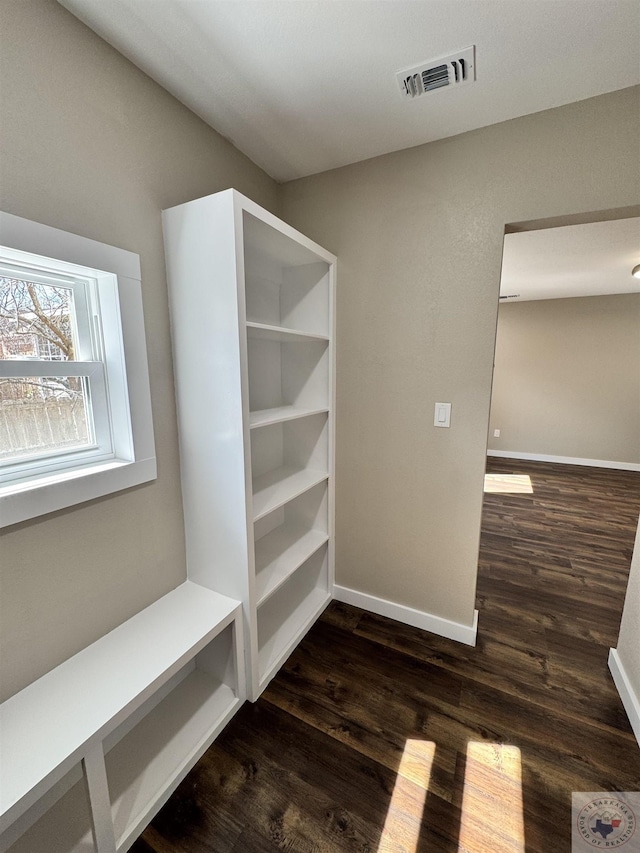 mudroom with dark wood-style floors, baseboards, and visible vents