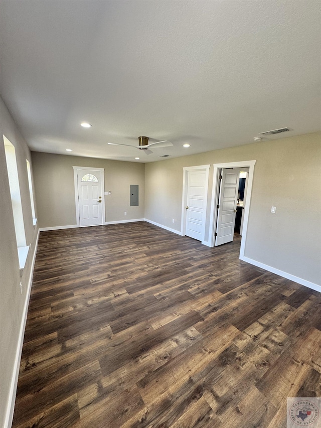 unfurnished room with dark wood-style floors, electric panel, visible vents, and baseboards