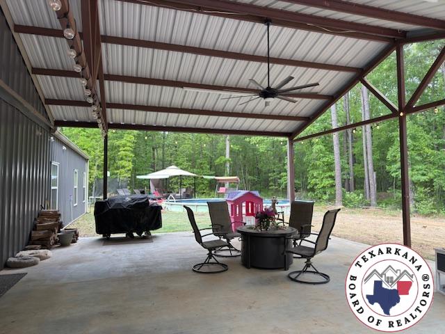 3059 Mc 22, Fouke, AR 71837 - view of patio / terrace featuring a ceiling fan, a grill, an outdoor pool, and a forest view