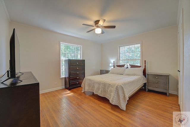 bedroom with light wood-type flooring, ceiling fan, and crown molding