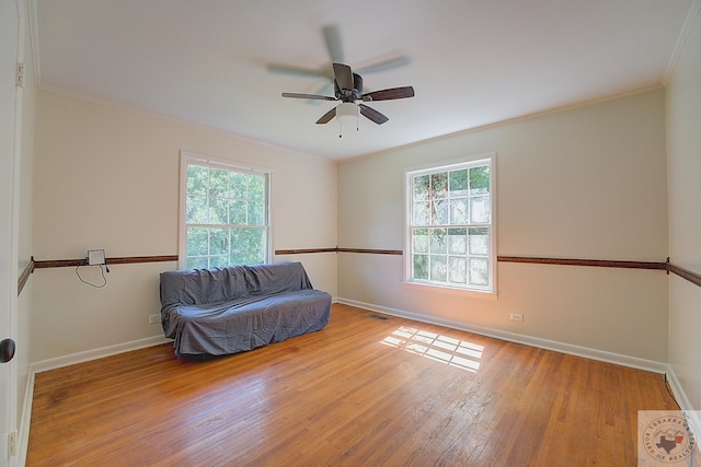 unfurnished room featuring ceiling fan, plenty of natural light, ornamental molding, and light wood-type flooring