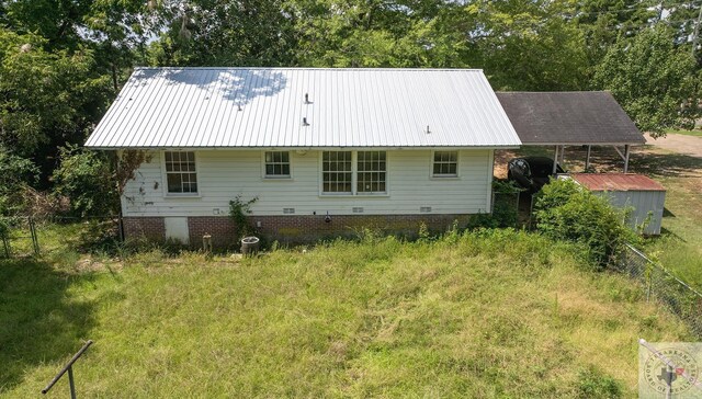 rear view of house with a storage shed and a carport