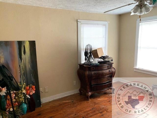 3812 Elizabeth St, Texarkana, TX 75501 - detailed view of a textured ceiling, ceiling fan, wood finished floors, and baseboards
