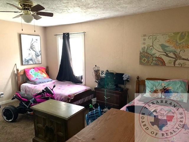 3812 Elizabeth St, Texarkana, TX 75501 - carpeted bedroom with ceiling fan and a textured ceiling