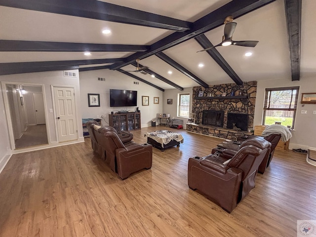 111 Oak St, New Boston, TX 75570 - living room featuring lofted ceiling with beams, visible vents, ceiling fan, a stone fireplace, and light wood-type flooring