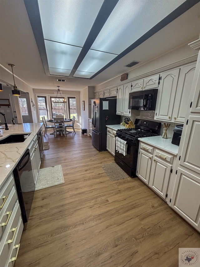 111 Oak St, New Boston, TX 75570 - kitchen featuring a sink, light stone counters, light wood finished floors, white cabinets, and black appliances