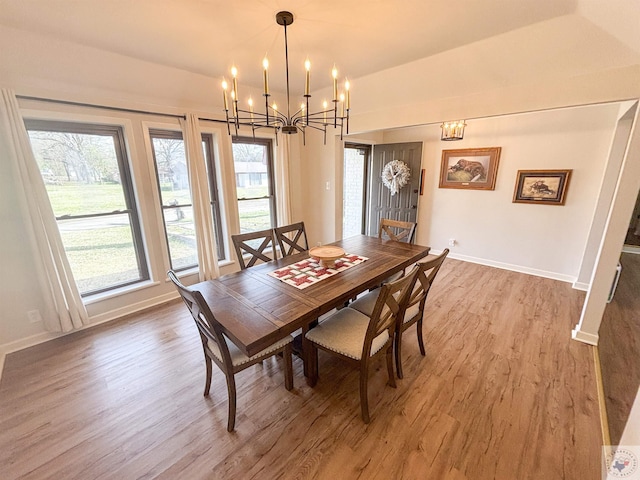 111 Oak St, New Boston, TX 75570 - dining room featuring baseboards, wood finished floors, a healthy amount of sunlight, and a notable chandelier