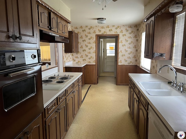 416 W Greenfield Dr, Wake Village, TX 75503 - kitchen with wall oven, dishwasher, a sink, a wainscoted wall, and light countertops