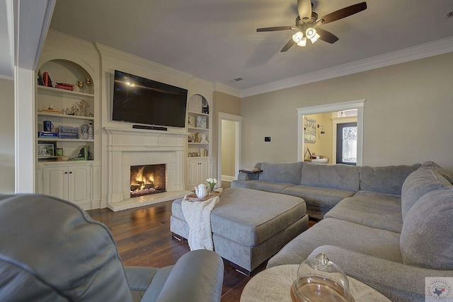 living room featuring built in features, dark hardwood / wood-style floors, a brick fireplace, and ornamental molding