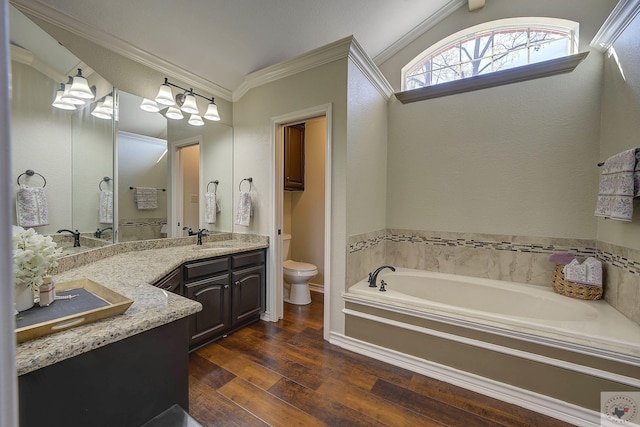 bathroom featuring wood-type flooring, vanity, toilet, a bath, and crown molding