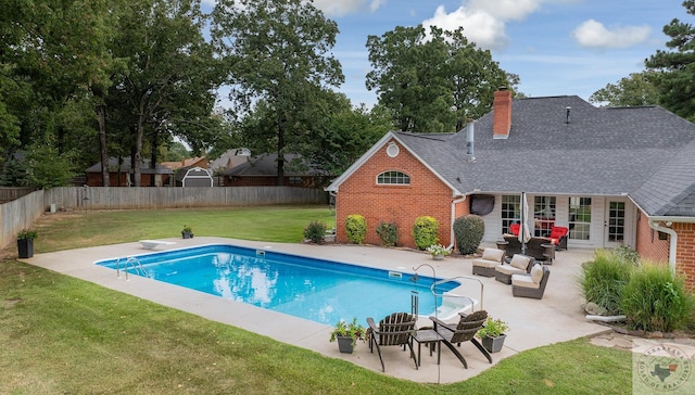 view of swimming pool with a diving board, a patio area, and a lawn