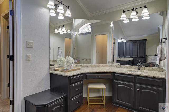 bathroom featuring hardwood / wood-style flooring, lofted ceiling, vanity, and ornamental molding