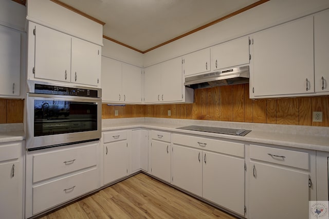 kitchen featuring stainless steel oven, black electric cooktop, light countertops, and under cabinet range hood