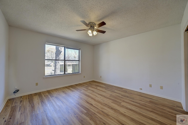 unfurnished room featuring ceiling fan, baseboards, light wood-type flooring, and a textured ceiling