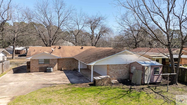 back of house with a patio, fence, brick siding, and driveway