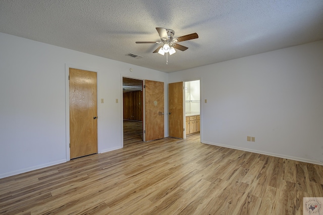 unfurnished bedroom with visible vents, a textured ceiling, light wood-type flooring, and baseboards