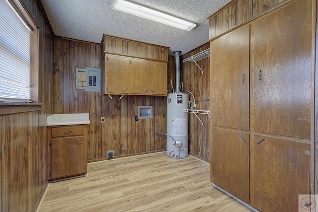 laundry room with cabinet space, gas water heater, hookup for a washing machine, and light wood-type flooring