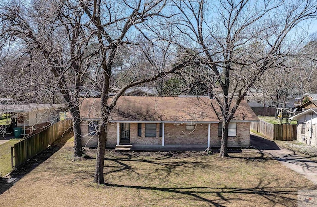 ranch-style house featuring fence, brick siding, and driveway