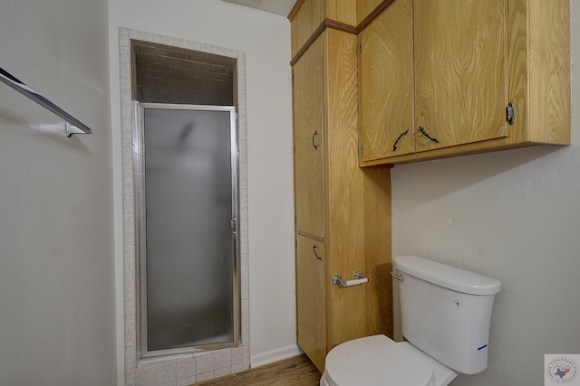 bathroom featuring toilet and a shower stall