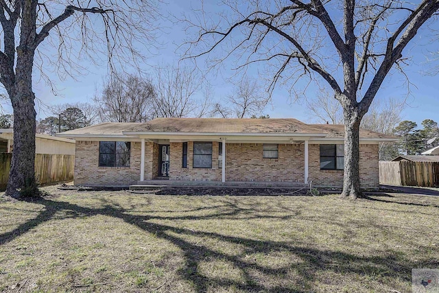 view of front of home featuring brick siding, a porch, a front yard, and fence