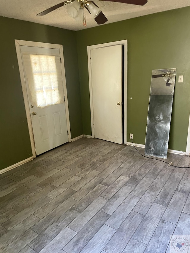 entrance foyer with hardwood / wood-style flooring, ceiling fan, and a textured ceiling