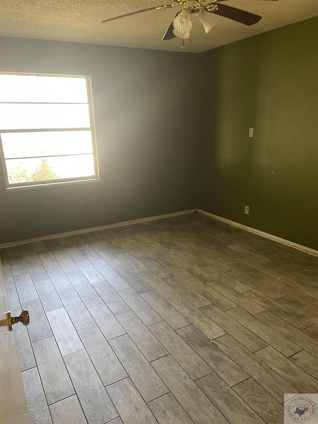 spare room featuring ceiling fan, wood-type flooring, and a textured ceiling