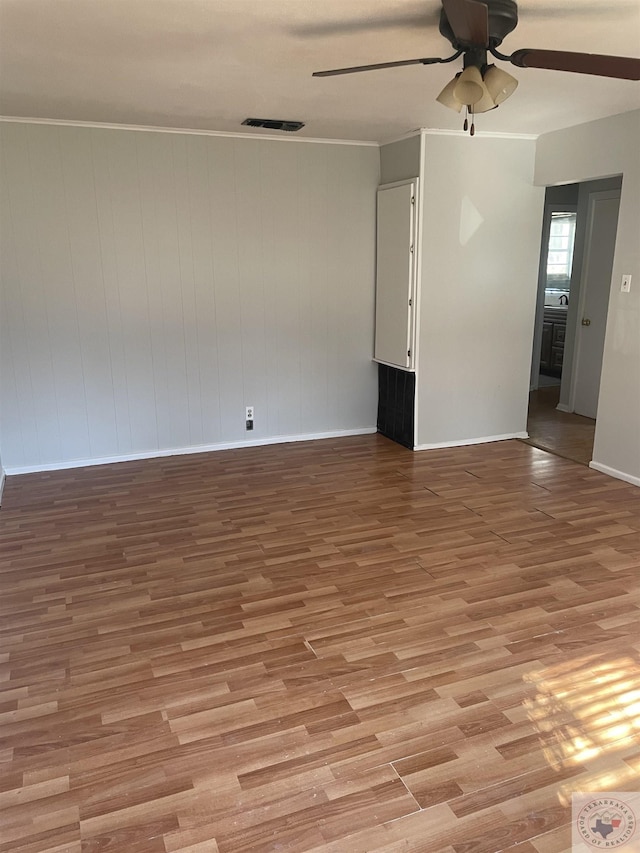 unfurnished room featuring ceiling fan, crown molding, and light hardwood / wood-style floors