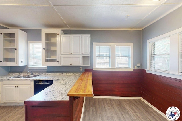 2006 Walnut St, Texarkana, TX 75501 - kitchen with a sink, black dishwasher, light wood-style flooring, light countertops, and glass insert cabinets