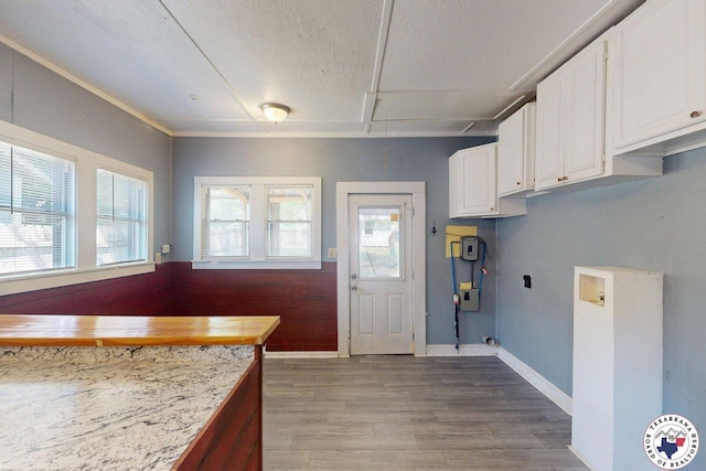 2006 Walnut St, Texarkana, TX 75501 - kitchen with white cabinetry, wood finished floors, light countertops, baseboards, and a textured ceiling
