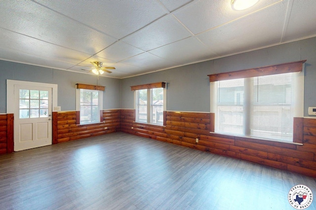2006 Walnut St, Texarkana, TX 75501 - empty room with log walls, wainscoting, wood finished floors, and ceiling fan