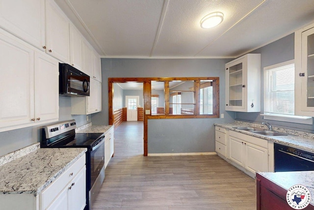2006 Walnut St, Texarkana, TX 75501 - kitchen with black appliances, a sink, light wood-type flooring, white cabinetry, and ornamental molding
