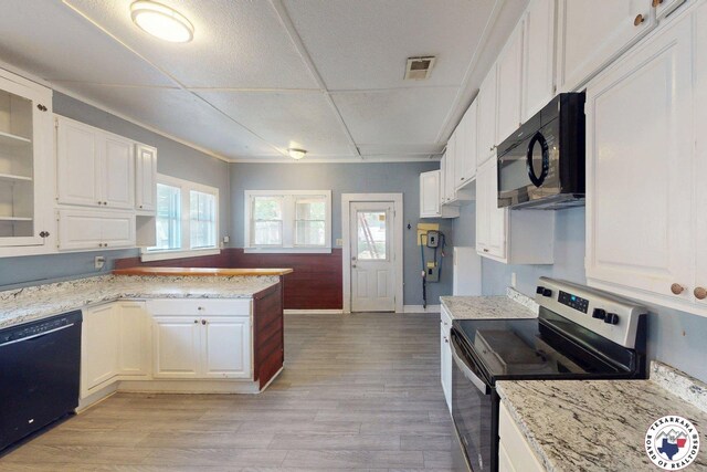 2006 Walnut St, Texarkana, TX 75501 - kitchen with black appliances, white cabinets, and light stone countertops