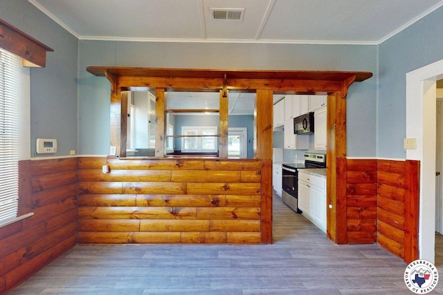 2006 Walnut St, Texarkana, TX 75501 - kitchen featuring stainless steel electric stove, rustic walls, wood finished floors, white cabinets, and black microwave