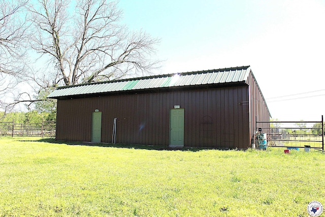 view of pole building with fence and a yard