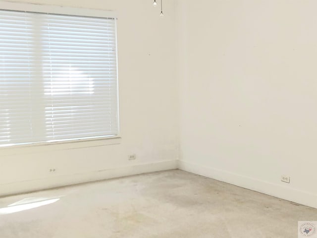 spare room with plenty of natural light and light carpet