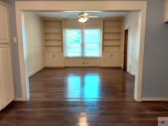 unfurnished dining area featuring built in shelves, dark hardwood / wood-style floors, and ceiling fan